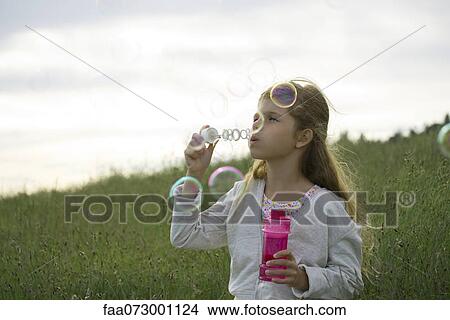 Picture - Girl blowing bubbles. Fotosearch