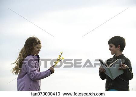 Girl giving boy wildflowers View Large Photo Image Stock Image - Girl giving boy wildflowers. Fotosearch