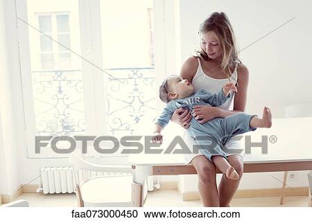 Girl holding baby sister on lap, portrait View Large Photo Image Stock Image - Girl holding baby sister on lap, portrait. Fotosearch