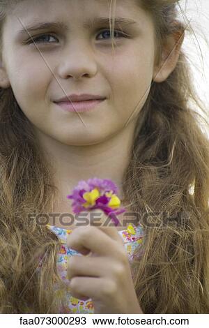 Stock Image - Girl holding bouquet of flowers, portrait. Fotosearch
