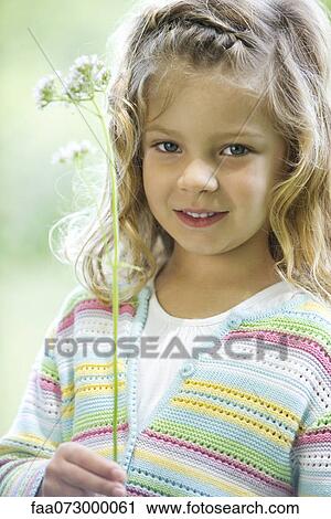 Girl holding wildflowers, portrait View Large Photo Image Stock Image - Girl holding wildflowers, portrait. Fotosearch