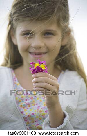 Girl holding wildflowers, portrait View Large Photo Image Stock Image - Girl holding wildflowers, portrait. Fotosearch