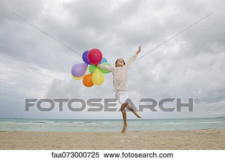 Girl jumping on beach with bunch of colorful balloons View Large Photo Image Stock Photography - Girl jumping on beach with bunch of colorful balloons. Fotosearch