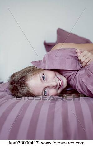 Girl lazing around on bed View Large Photo Image Stock Photo - Girl lazing around on bed. Fotosearch