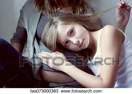 Girl listening to mother's abdomen View Large Photo Image Stock Image - Girl listening to mother's abdomen. Fotosearch