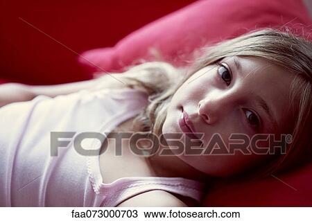 Girl lying on couch, portrait View Large Photo Image Stock Image - Girl lying on couch, portrait. Fotosearch