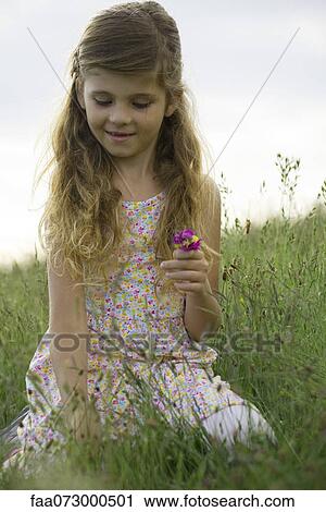 Stock Image - Girl picking wildflowers. Fotosearch