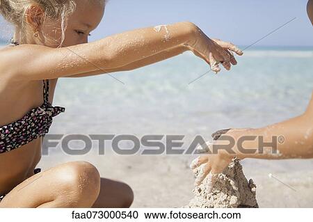 Girl playing in sand at the beach View Large Photo Image Stock Image - Girl playing in sand at the beach. Fotosearch