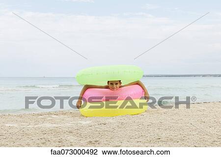 Girl playing with stack of inflatable rings on beach View Large Photo Image Stock Image - Girl playing with stack of inflatable rings on beach. Fotosearch