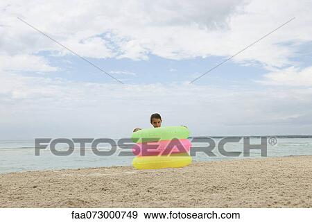 Girl playing with stack of infltable rings on beach View Large Photo Image Stock Photo - Girl playing with stack of infltable rings on beach. Fotosearch