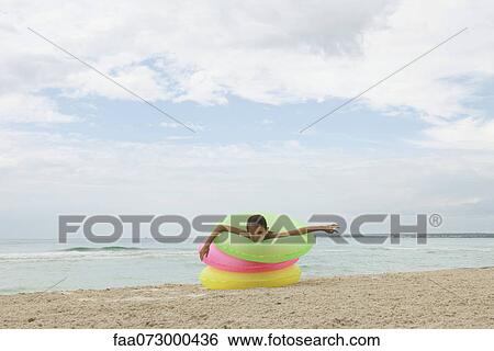 Girl playing with stack of infltable rings on beach View Large Photo Image Stock Photograph - Girl playing with stack of infltable rings on beach. Fotosearch