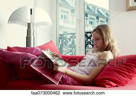 Girl relaxing on couch reading book View Large Photo Image Stock Image - Girl relaxing on couch reading book. Fotosearch