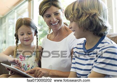 Grandmother and grandchildren using digital tablet View Large Photo Image Stock Image - Grandmother and grandchildren using digital tablet. Fotosearch