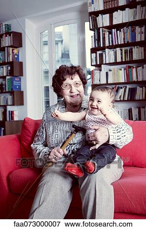 Stock Photo - Grandmother holding baby granddaughter, portrait. Fotosearch