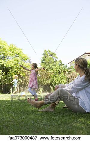 Grandmother sitting on grass watching grandchildren play View Large Photo Image Stock Photo - Grandmother sitting on grass watching grandchildren play. Fotosearch