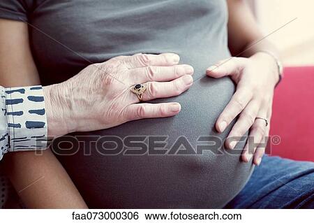 Hands on pregnant woman's abdomen View Large Photo Image Stock Photograph - Hands on pregnant woman's abdomen. Fotosearch