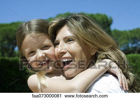 Stock Image - Happy mother and daughter embracing. Fotosearch