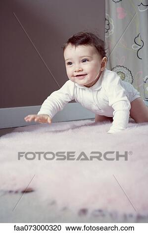 Stock Image - Infant crawling on floor. Fotosearch