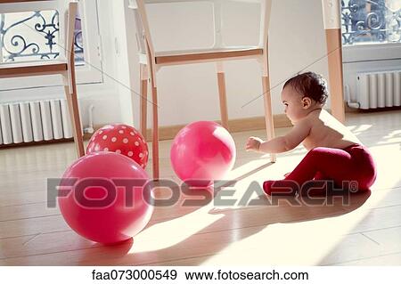 Stock Photo - Infant playing with ballons. Fotosearch