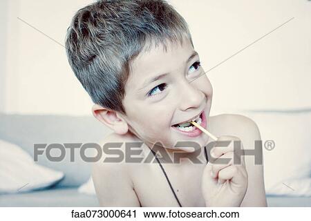 Little boy eating lollipop, portrait View Large Photo Image Stock Image - Little boy eating lollipop, portrait. Fotosearch