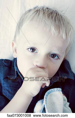 Stock Photo - Little boy sucking his thumb, portrait. Fotosearch