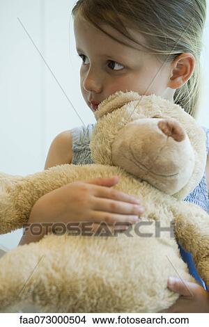Picture - Little girl hugging teddy bear. Fotosearch