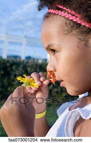 Picture - Little girl smelling flowers, profile. Fotosearch