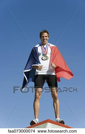 Male athlete being honored on podium, wrapped in French flag View Large Photo Image Picture - Male athlete being honored on podium, wrapped in French flag. Fotosearch