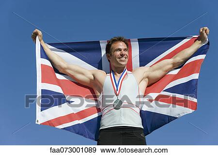Male athlete on winner's podium, holding up British flag View Large Photo Image Stock Photo - Male athlete on winner's podium, holding up British flag. Fotosearch