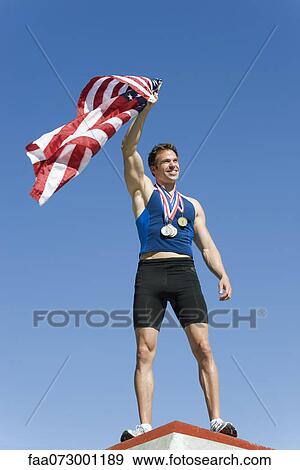 Male athlete on winner's podium, holding up American flag View Large Photo Image Stock Photo - Male athlete on winner's podium, holding up American flag. Fotosearch