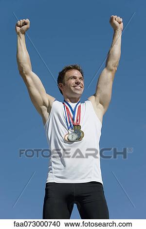 Male athlete with arms raised in victory View Large Photo Image Stock Image - Male athlete with arms raised in victory. Fotosearch