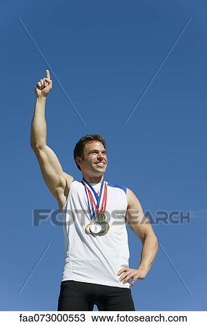 Male athlete with hand raised in victory View Large Photo Image Stock Image - Male athlete with hand raised in victory. Fotosearch