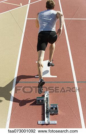 Man running on track, rear view View Large Photo Image Stock Image - Man running on track, rear view. Fotosearch