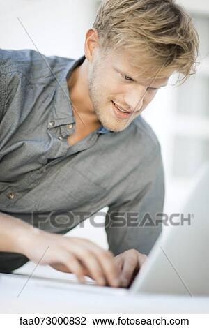 Stock Image - Man using laptop computer. Fotosearch