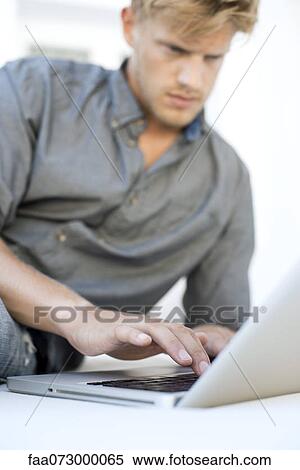 Stock Photography - Man using laptop computer. Fotosearch