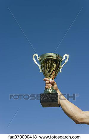 Stock Photo - Man's arm holding up trophy. Fotosearch