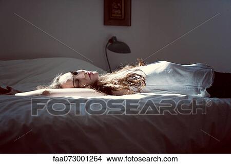 Mid-adult woman napping on bed View Large Photo Image Picture - Mid-adult woman napping on bed. Fotosearch