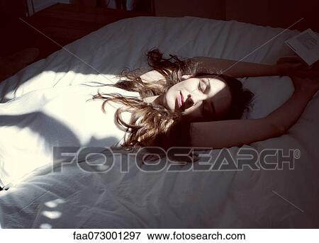 Mid-adult woman relaxing on bed View Large Photo Image Stock Photo - Mid-adult woman relaxing on bed. Fotosearch