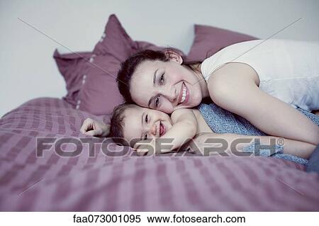 Mother and infant lying on bed View Large Photo Image Stock Photography - Mother and infant lying on bed. Fotosearch