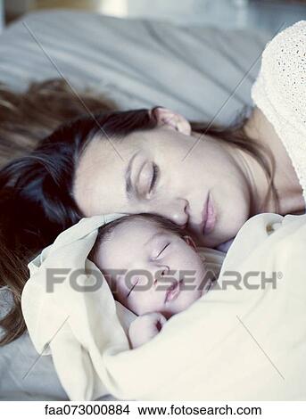 Mother and new born baby sleeping in bed View Large Photo Image Picture - Mother and new born baby sleeping in bed. Fotosearch