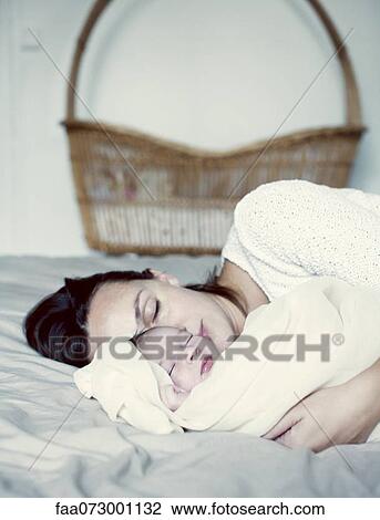 Mother and new born baby sleeping in bed View Large Photo Image Stock Image - Mother and new born baby sleeping in bed. Fotosearch