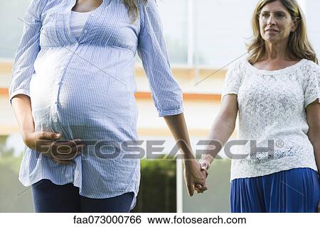 Mother and pregnant daughter holding hands View Large Photo Image Stock Photograph - Mother and pregnant daughter holding hands. Fotosearch