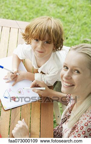 Mother and son coloring together, high angle view View Large Photo Image Stock Photo - Mother and son coloring together, high angle view. Fotosearch