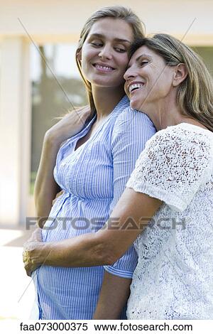 Mother hugging pregnant daughter View Large Photo Image Stock Photography - Mother hugging pregnant daughter. Fotosearch