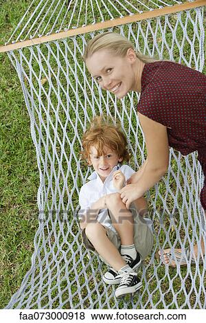 Stock Photo - Mother tickling son in hammock. Fotosearch