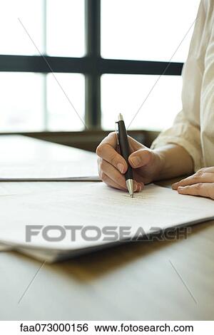 Stock Photograph - Person signing contract, cropped. Fotosearch