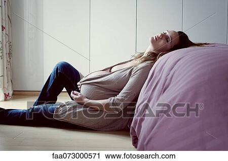 Pregnant woman leaning against bed resting View Large Photo Image Stock Image - Pregnant woman leaning against bed resting. Fotosearch