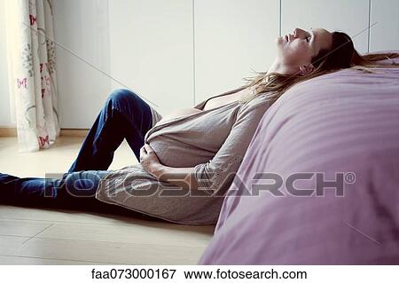 Pregnant woman leaning against bed resting View Large Photo Image Stock Photo - Pregnant woman leaning against bed resting. Fotosearch