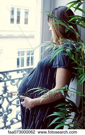 Pregnant woman looking out of window View Large Photo Image Stock Image - Pregnant woman looking out of window. Fotosearch