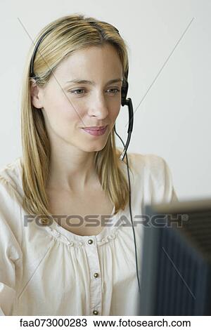Stock Image - Professional woman wearing headset. Fotosearch
